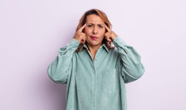 Orta yaşlı kadın odaklanmış ve bir fikir üzerinde kafa yoruyor, bir soruna ya da soruna bir çözüm hayal ediyor.