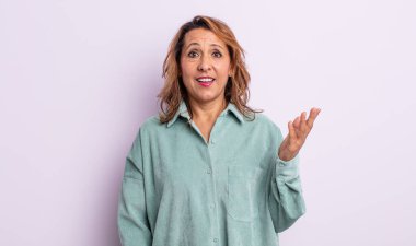 Orta yaşlı bir kadın mutlu, şaşırmış ve neşeli, pozitif bir tavırla gülümsüyor, bir çözüm ya da fikir buluyor.