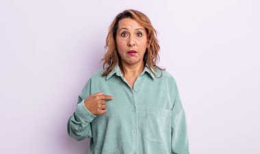 Orta yaşlı bir kadın şaşkın, şaşkın ve güvensiz hissediyor. Kendini gösterip kim olduğunu soruyor, ben mi??