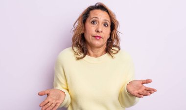 Orta yaşlı kadın şaşkın ve kafası karışmış hissediyor, doğru cevap ya da karardan emin değil, bir seçim yapmaya çalışıyor.