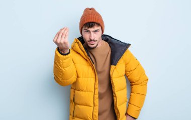 Genç yakışıklı adam kapiş ya da para hareketi yapıyor, sana ödemeni söylüyor. kış konsepti