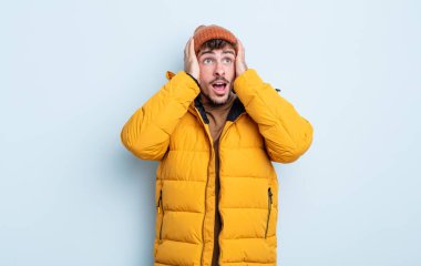 Genç yakışıklı adam mutlu, heyecanlı ve şaşırmış hissediyor. kış konsepti