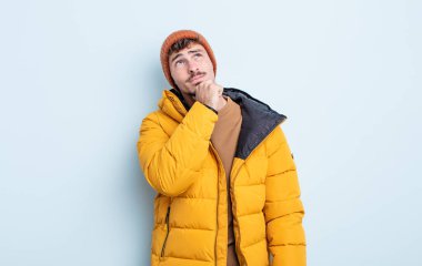 Genç yakışıklı düşünen, kuşkulu ve kafası karışık bir adam. kış konsepti