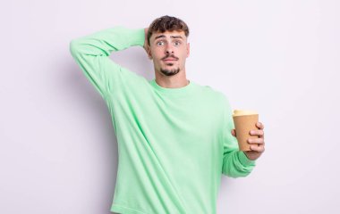 Genç ve yakışıklı bir adam stresli, endişeli ya da korkmuş hissediyor. Elleri başının üstünde. kahve konseptini kaldır.
