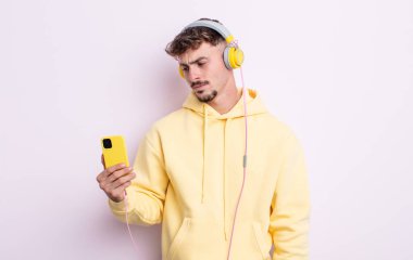 Genç ve yakışıklı bir adam üzgün, üzgün ya da kızgın hissediyor ve yan tarafa bakıyor. müzik konsepti