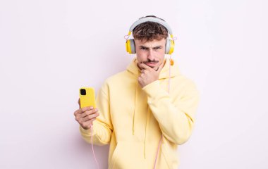 Ağzı ve gözleri açık ve eli çenesinde genç yakışıklı bir adam. müzik konsepti