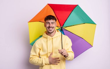 Genç yakışıklı bir adam komik bir şakaya yüksek sesle gülüyor. şemsiye kavramı