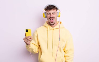 Genç ve yakışıklı bir adam tiksinmiş ve sinirlenmiş hissediyor ve dilini dışarı çıkarıyor. müzik konsepti