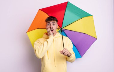 Genç ve yakışıklı bir adam şok olmuş ve korkmuş hissediyor. şemsiye kavramı