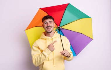 Genç yakışıklı adam heyecanlı ve şaşırmış görünüyor. şemsiye kavramı