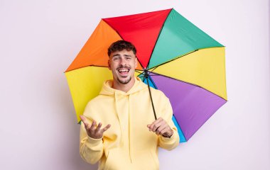 Genç yakışıklı adam umutsuz, sinirli ve stresli görünüyor. şemsiye kavramı