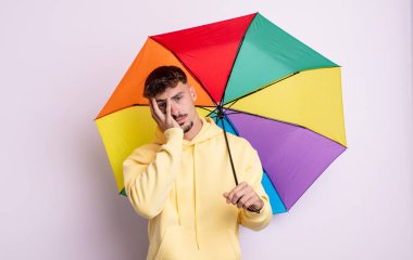 Genç yakışıklı bir adam bıkkın, hayal kırıklığına uğramış ve yorucu bir geceden sonra uykulu hissediyor. şemsiye kavramı