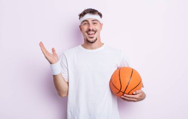 Genç yakışıklı adam kendini mutlu hissediyor ve inanılmaz bir şeye hayret ediyor. Basketbol konsepti