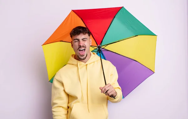 Mladý Pohledný Muž Veselým Vzpurným Přístupem Vtipem Vystrčeným Jazykem Deštníkový — Stock fotografie