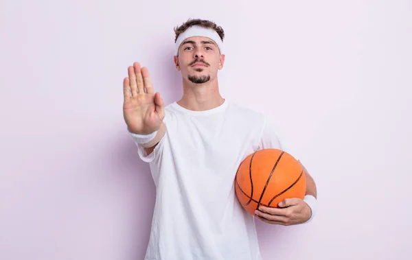 年轻英俊的男人看上去很严肃 露出了张开手掌的停止姿势 篮球概念 — 图库照片