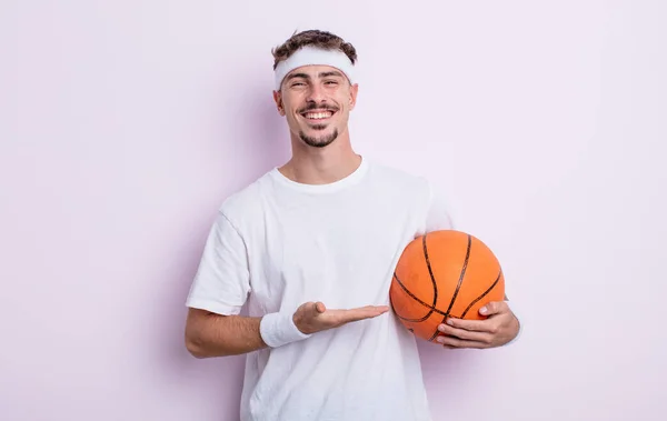年轻英俊的男人兴高采烈地笑着 感到快乐 并表现出一种观念 篮球概念 — 图库照片