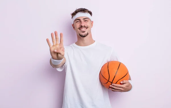 年轻英俊的男人面带微笑 看上去很友善 显示出第四 篮球概念 — 图库照片