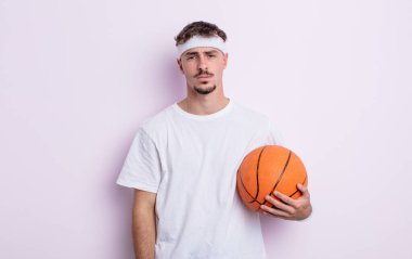 Genç ve yakışıklı bir adam üzgün ve mızmızlanıyor. Mutsuz bir bakışı var ve ağlıyor. Basketbol konsepti