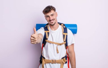 Genç ve yakışıklı bir adam gururlu, olumlu gülümsüyor. Yürüyüş konsepti