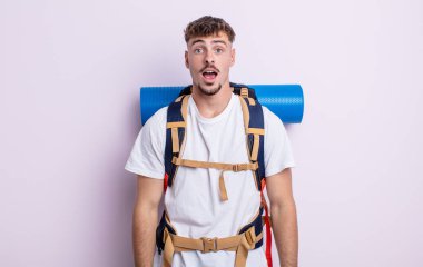 Genç ve yakışıklı bir adam çok şaşırmış ya da şaşkın görünüyor. Yürüyüş konsepti