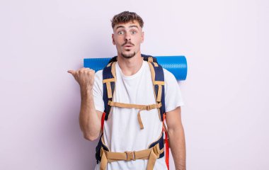 İnanamadığı için şaşırmış genç ve yakışıklı bir adam. Yürüyüş konsepti