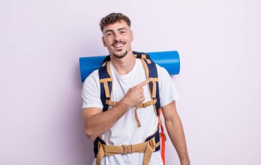 Genç yakışıklı adam heyecanlı ve şaşırmış görünüyor. Yürüyüş konsepti