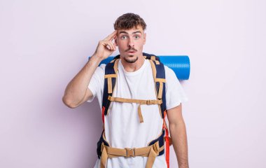 Genç yakışıklı adam şaşırmış görünüyor, yeni bir düşünce, fikir ya da konsept fark ediyor. Yürüyüş konsepti