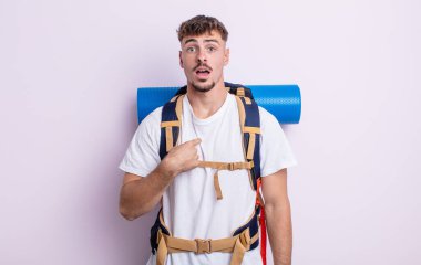 Şok olmuş ve ağzı açık, kendini işaret eden genç ve yakışıklı bir adam. Yürüyüş konsepti