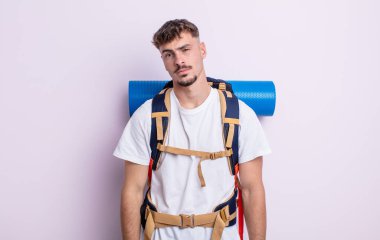 Genç yakışıklı adam şaşkın ve şaşkın hissediyor. Yürüyüş konsepti