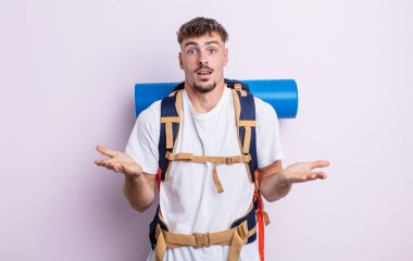 Genç ve yakışıklı bir adam şok olmuş ve şaşırmış hissediyor. Yürüyüş konsepti