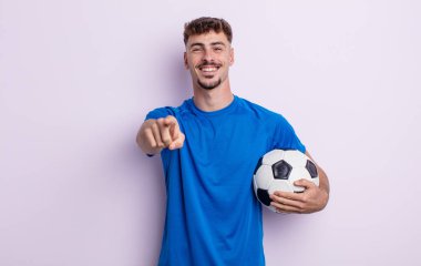 Genç ve yakışıklı bir adam kamerayı işaret ederek seni seçiyor. futbol kavramı