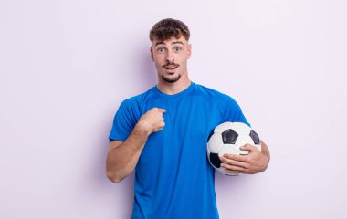 Genç ve yakışıklı bir adam mutlu hissediyor ve heyecanla kendini işaret ediyor. futbol kavramı