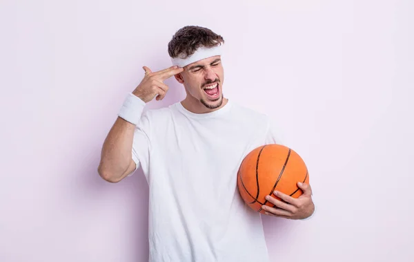 年轻英俊的男人看上去很不高兴 很紧张 做着自杀手势 在枪口上签了名 篮球概念 — 图库照片