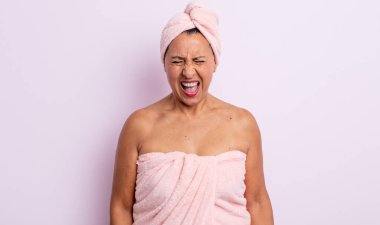 Oldukça orta yaşlı bir kadın agresif bir şekilde bağırıyor, çok kızgın görünüyor. güzellik ve duş konsepti