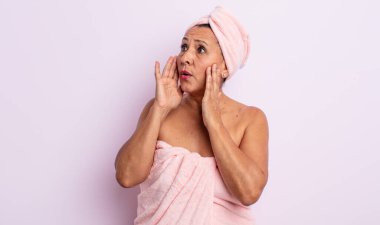 Oldukça orta yaşlı bir kadın mutlu, heyecanlı ve şaşırmış hissediyor. güzellik ve duş konsepti