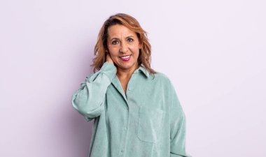 Orta yaşlı bir kadın neşeli ve kendinden emin bir şekilde gülüyor.