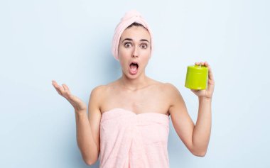 Genç ve güzel bir kadın şok olmuş ve şaşırmış hissediyor. duş ve saç ürünü konsepti