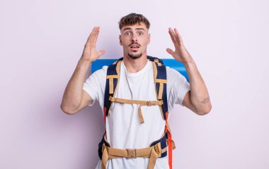 Genç yakışıklı adam ellerini havaya kaldırarak çığlık atıyor. Yürüyüş konsepti