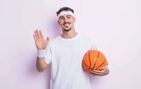 年轻英俊的男人快乐地笑着 挥挥手 欢迎并问候你 篮球概念 — 图库照片