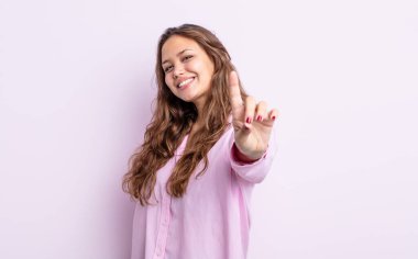 İspanyol güzel kadın gururla gülümsüyor ve bir numaralı pozu başarıyla veriyor, kendini lider gibi hissediyor.