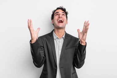 Genç işadamı kendini mutlu, şaşkın, şanslı ve şaşırmış hissediyor. Zaferi kutlarken iki elini de havaya kaldırıyor.