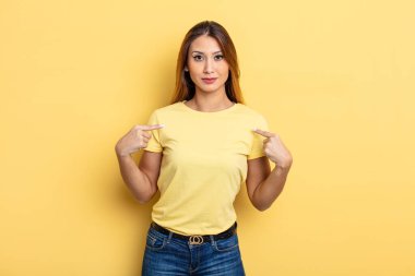 Asyalı güzel bir kadın gururlu, pozitif ve iki eliyle göğsünü gösteren