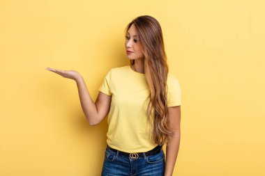 Asyalı güzel bir kadın kendini mutlu hissediyor ve gülümsüyor. Yan taraftaki bir nesneye ya da konsepte bakıyor.