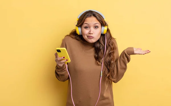 Hispanic Pretty Woman Feeling Puzzled Confused Doubting Headphones Smartphone Concept — Stock Photo, Image