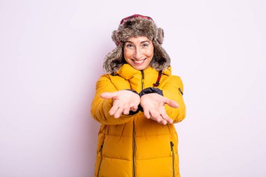 Kıdemli, güzel bir bayan arkadaşça gülümsüyor ve bir konsept sunuyor. kış konsepti