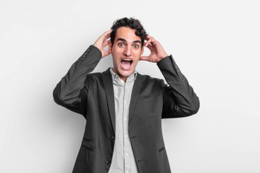 Genç işadamı el ele tutuşuyor, ağzı açık, son derece şanslı, şaşırmış, heyecanlı ve mutlu hissediyor.