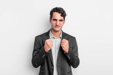 Genç işadamı kendinden emin, sinirli, güçlü ve agresif görünüyor. Yumrukları boks pozisyonunda dövüşmeye hazır.