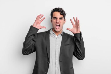 Genç işadamı elleri havada bağırıyor, öfkeli, sinirli, stresli ve üzgün hissediyor.