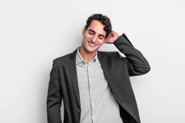 Genç işadamı neşeli ve rahat bir şekilde gülümsüyor, olumlu, mutlu ve kendinden emin bir bakışla göğüs göğüse tutuşuyor.