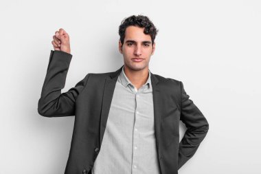 Genç işadamı kendini ciddi, güçlü ve asi hissediyor, yumruğunu kaldırıyor, protesto ediyor ya da devrim için savaşıyor.